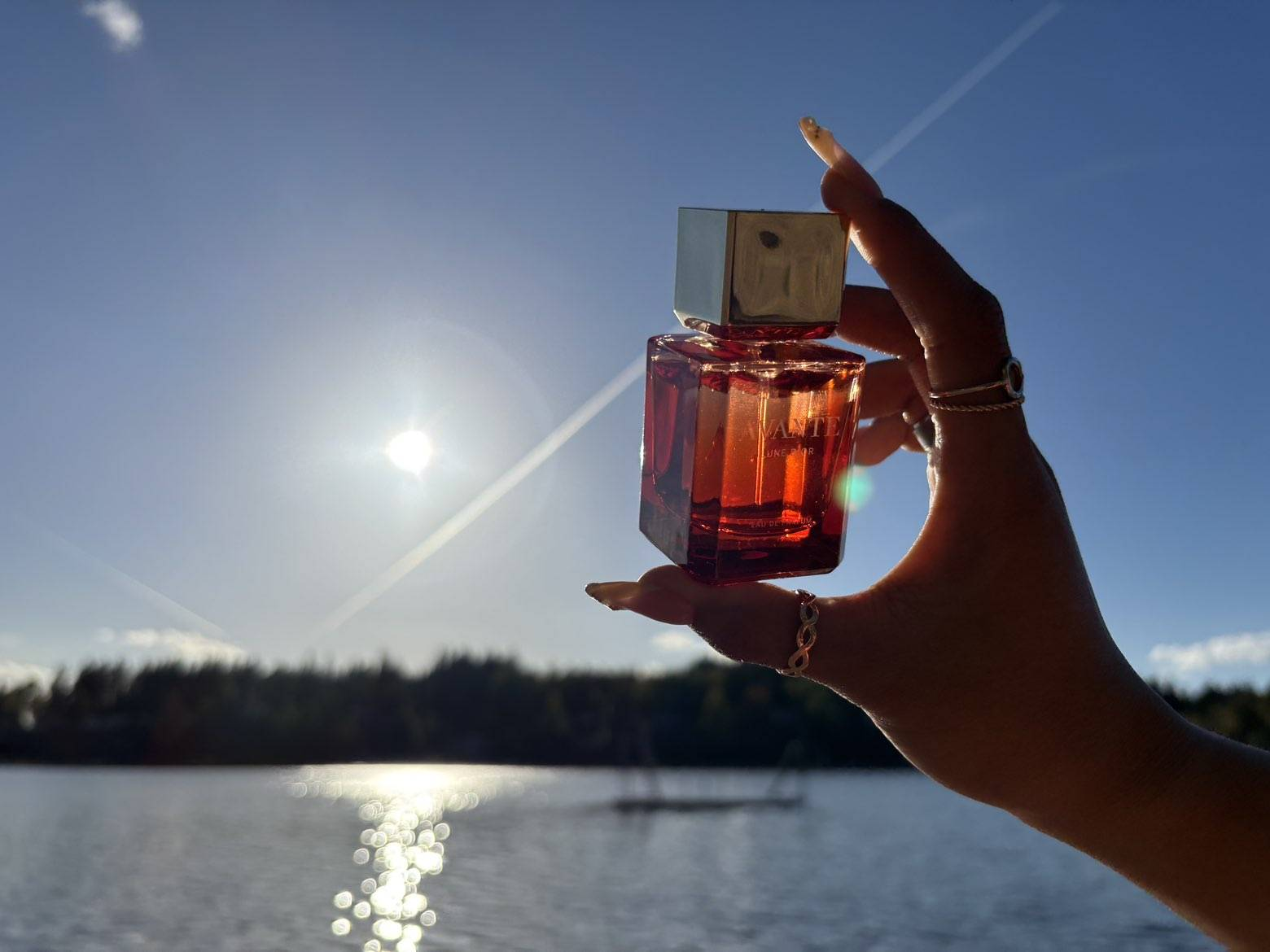 Lune D’Or held up against the sun over a lake